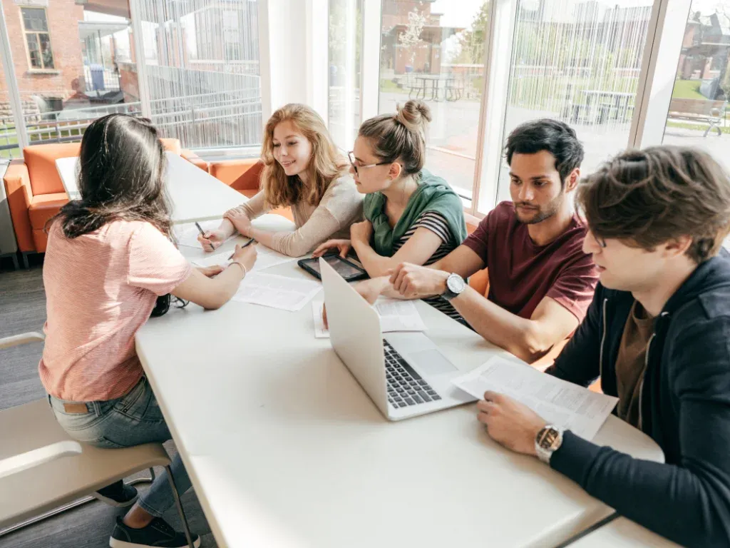 Young professionals collaborating around a table with laptops